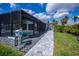 Landscaped backyard with screened-in patio, pool, and stone walkway at 129 Barre Nw Dr, Port Charlotte, FL 33952