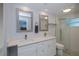 Bright bathroom features a double vanity, walk-in shower, and tile flooring at 129 Barre Nw Dr, Port Charlotte, FL 33952
