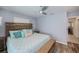 Relaxing bedroom featuring wood-look floors, a ceiling fan, and a wooden bed frame and headboard at 129 Barre Nw Dr, Port Charlotte, FL 33952