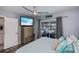 Comfortable bedroom features TV, ceiling fan, and sliding glass door to the screened patio at 129 Barre Nw Dr, Port Charlotte, FL 33952