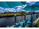 Waterfront property with dock featuring comfortable blue patio furniture with adjacent waterfront views at 129 Barre Nw Dr, Port Charlotte, FL 33952
