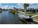 Waterfront with boat dock for easy access to the water, featuring Adirondack chairs for relaxing by the canal at 129 Barre Nw Dr, Port Charlotte, FL 33952