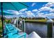 Waterfront property with dock featuring boat, boat lift, and blue patio furniture with an umbrella at 129 Barre Nw Dr, Port Charlotte, FL 33952