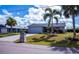 Charming single-story home with two-car garage, well-manicured lawn, and tropical landscaping at 129 Barre Nw Dr, Port Charlotte, FL 33952
