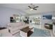 Open living area with tile floors, ceiling fan, and seamless transition to the kitchen at 129 Barre Nw Dr, Port Charlotte, FL 33952