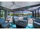 Relaxing screened patio boasts comfortable seating around a modern fire pit, with a view of the pool and backyard at 129 Barre Nw Dr, Port Charlotte, FL 33952