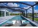 Stunning pool features submerged chaise lounges and a tranquil water feature, set against a backdrop of canal views at 129 Barre Nw Dr, Port Charlotte, FL 33952