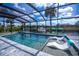 Gorgeous pool with submerged chaise lounges offers a relaxing retreat with views of the canal and a boat dock at 129 Barre Nw Dr, Port Charlotte, FL 33952