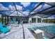 Inviting screened pool area with a relaxing lounge area, stylish furniture, and outdoor kitchen at 129 Barre Nw Dr, Port Charlotte, FL 33952