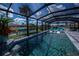 Beautiful pool with water feature offers a serene escape with views of the canal and inviting chaise lounges at 129 Barre Nw Dr, Port Charlotte, FL 33952