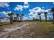 Large lot with palm trees, grass, and a partial view of the neighboring homes at 129 Barre Nw Dr, Port Charlotte, FL 33952