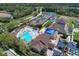 Aerial view of community pool, tennis courts, clubhouse, parking, and surrounding landscape at 13049 Creekside Ln, Port Charlotte, FL 33953