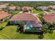 Aerial view of property with enclosed pool, lush landscaping and attractive tile roof at 13049 Creekside Ln, Port Charlotte, FL 33953