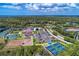 An aerial view shows the community's tennis and pickleball courts, dog park, and beautiful landscape at 13049 Creekside Ln, Port Charlotte, FL 33953