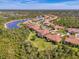 Stunning aerial view of a community showcasing beautiful homes with red tile roofs near a scenic lake at 13049 Creekside Ln, Port Charlotte, FL 33953