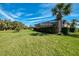 Beautiful backyard with lush green grass, mature trees and a private screened-in pool area at 13049 Creekside Ln, Port Charlotte, FL 33953