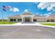 Well-manicured clubhouse exterior with flags and covered entrance at 13049 Creekside Ln, Port Charlotte, FL 33953