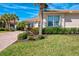 Lovely home with pristine landscaping featuring lush green grass, colorful plants, and towering palm trees at 13049 Creekside Ln, Port Charlotte, FL 33953