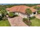 Beautiful home with a clay tile roof, brick paver driveway and mature landscaping at 13049 Creekside Ln, Port Charlotte, FL 33953