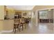 Open kitchen with stainless appliances, granite countertops and breakfast bar flows into the dining and living spaces at 13049 Creekside Ln, Port Charlotte, FL 33953