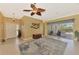 Open living room with a ceiling fan and access to the foyer and screened-in lanai at 13049 Creekside Ln, Port Charlotte, FL 33953