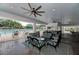 Inviting outdoor lounge area with comfortable seating, ceiling fans, and pool view at 13049 Creekside Ln, Port Charlotte, FL 33953