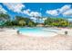 Inviting community pool with shallow entry, lush greenery, and ample seating for residents to relax and enjoy the outdoors at 13049 Creekside Ln, Port Charlotte, FL 33953