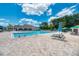 Spacious community pool area with comfortable lounge chairs and umbrellas, perfect for relaxation and enjoying the sunny weather at 13049 Creekside Ln, Port Charlotte, FL 33953