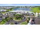 Overhead view of the community clubhouse and a serene lake surrounded by residential buildings and manicured landscapes at 14724 Cherry Blossom Way, Punta Gorda, FL 33955