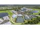 Community aerial showcasing a golf course, tennis courts, clubhouse, pool, and beautiful lakes amidst lush landscape at 14724 Cherry Blossom Way, Punta Gorda, FL 33955