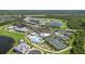 Community aerial view featuring golf course, clubhouse, pool, tennis courts, and scenic lakes surrounded by residences at 14724 Cherry Blossom Way, Punta Gorda, FL 33955
