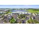 Community clubhouse featuring a gray roof, ample parking, and picturesque lake views surrounded by lush greenery at 14724 Cherry Blossom Way, Punta Gorda, FL 33955