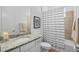 Bathroom features a granite vanity, toilet, and a shower/tub with a striped curtain at 14724 Cherry Blossom Way, Punta Gorda, FL 33955