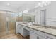 Bathroom featuring double sinks, granite countertops, and a tiled walk-in shower at 14724 Cherry Blossom Way, Punta Gorda, FL 33955