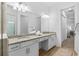 Bathroom with dual sinks, granite countertops, and a large framed mirror at 14724 Cherry Blossom Way, Punta Gorda, FL 33955