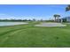 A view of a well-maintained golf course with lush green grass, sand traps, and a serene pond at 14724 Cherry Blossom Way, Punta Gorda, FL 33955