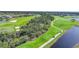Aerial view of golf course showcasing lush greenery, serene lakes and residential development at 14724 Cherry Blossom Way, Punta Gorda, FL 33955