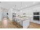 Well-lit kitchen with a central island, stainless steel appliances, and wood flooring at 14724 Cherry Blossom Way, Punta Gorda, FL 33955