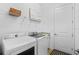 Bright laundry room with a front-load washer and dryer and storage shelves at 14724 Cherry Blossom Way, Punta Gorda, FL 33955