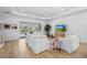 Bright living room with neutral furniture, wood-look floors, and access to an outdoor pool area at 14724 Cherry Blossom Way, Punta Gorda, FL 33955