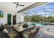 Covered outdoor dining and living space featuring a table for six and a view of the pool at 14724 Cherry Blossom Way, Punta Gorda, FL 33955