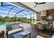Covered outdoor living space with a full kitchen, dining area, lounge seating, and a pool with a spa at 14724 Cherry Blossom Way, Punta Gorda, FL 33955
