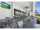 Covered outdoor seating area featuring tables, chairs, and a bar with views of the grounds at 14724 Cherry Blossom Way, Punta Gorda, FL 33955