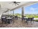 Covered outdoor seating area with tables and chairs, overlooking the community's putting green and water feature at 14724 Cherry Blossom Way, Punta Gorda, FL 33955