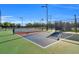 A view of pickleball court with green and blue surface, surrounded by a black fence at 14724 Cherry Blossom Way, Punta Gorda, FL 33955