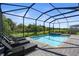 Screened-in pool and spa area with brick pavers and lounge chairs overlooking a green lawn at 14724 Cherry Blossom Way, Punta Gorda, FL 33955
