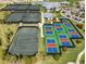 Aerial view of tennis and pickleball courts surrounded by lush landscaping and community amenities at 14724 Cherry Blossom Way, Punta Gorda, FL 33955