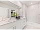 Modern bathroom with double vanity, white countertops, and a tiled walk-in shower at 16408 Bridle Ridge St, Port Charlotte, FL 33953