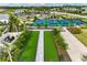 Aerial shot features manicured bocce ball courts and pickleball courts, surrounded by landscaping and walking paths at 16408 Bridle Ridge St, Port Charlotte, FL 33953