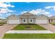 Beautiful exterior view of a modern, two-story home with a manicured lawn and brick paver driveway at 16408 Bridle Ridge St, Port Charlotte, FL 33953